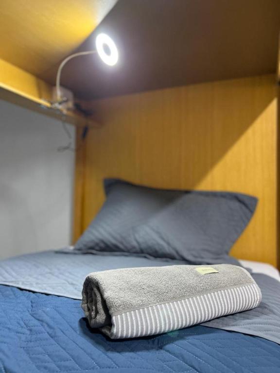 Cama individual con luz y toalla enrollada