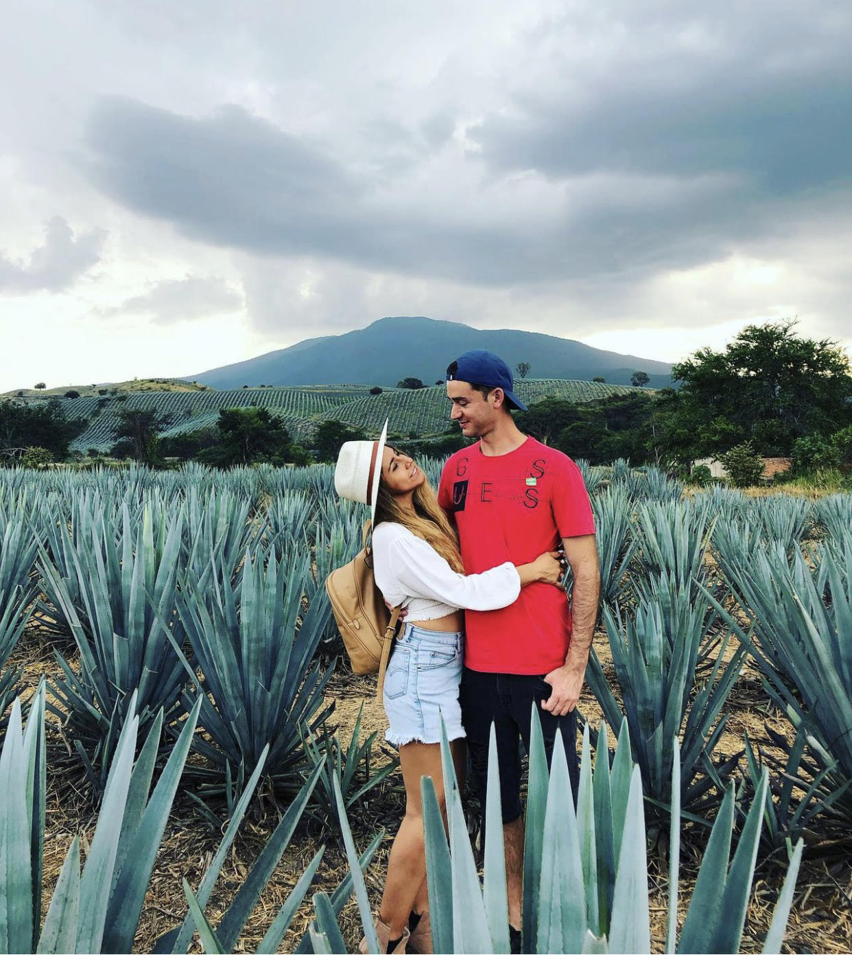 Pareja abrazada en plantación de agave.