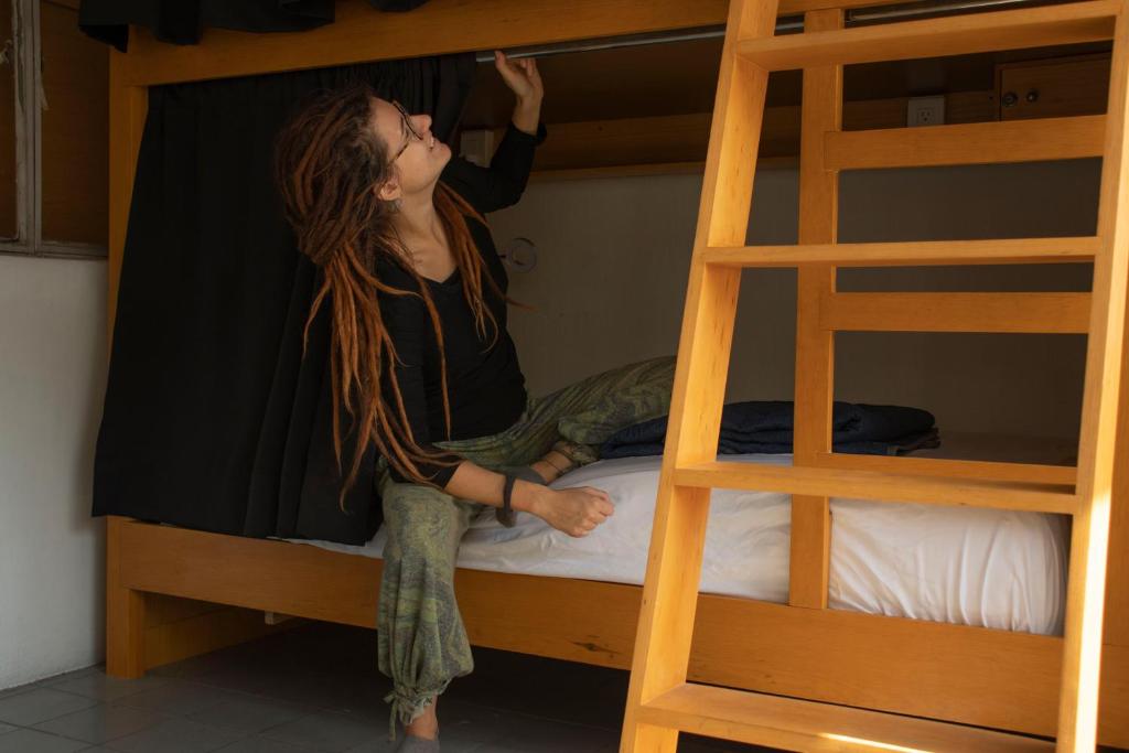 Persona ajusta cortina en cama litera.