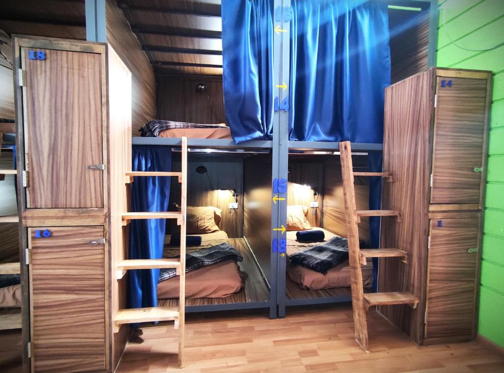 Camas en litera con lockers y cortinas azules.