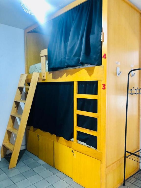 Literas de madera con cortinas negras en hostal.