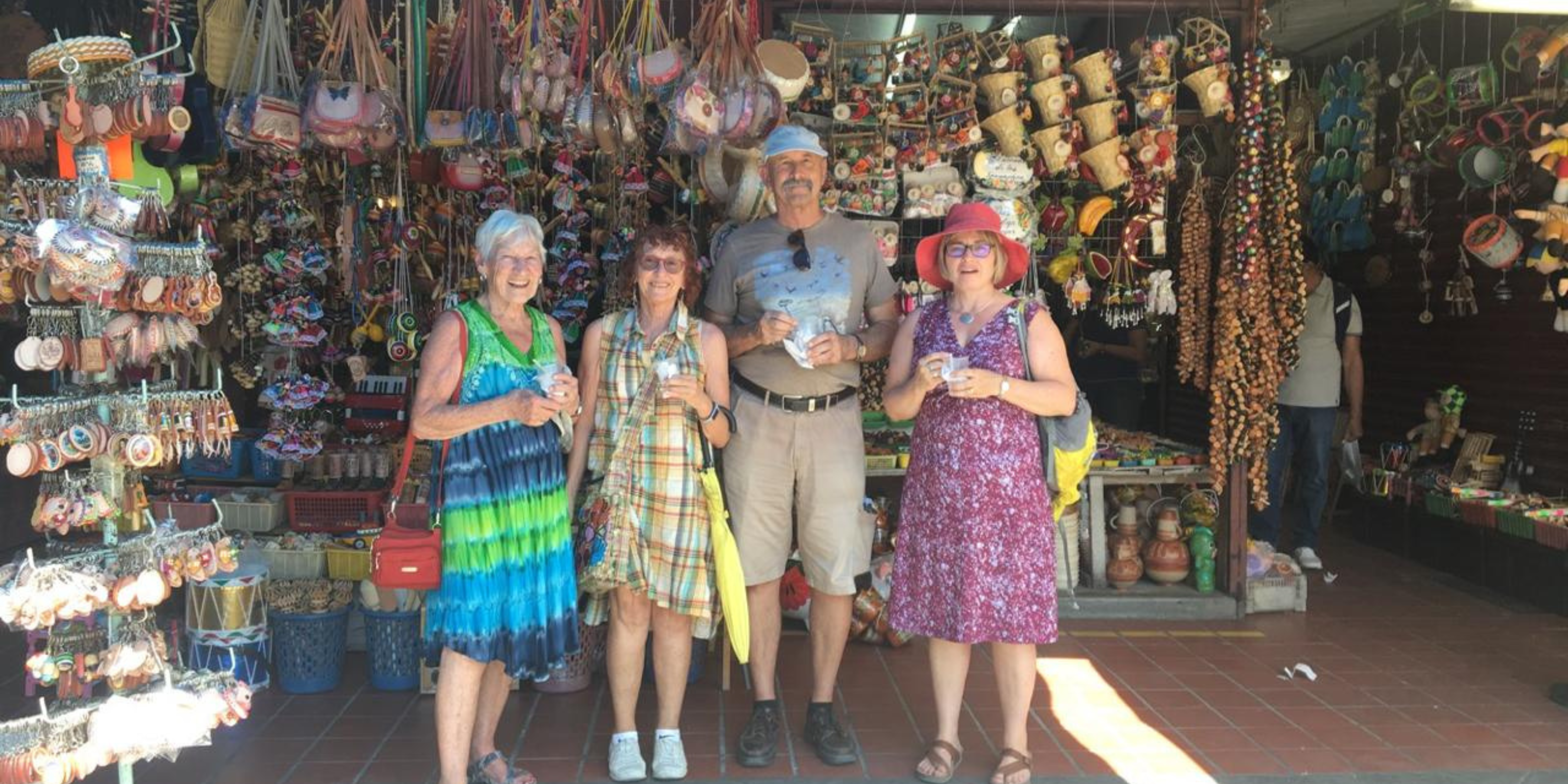Turistas en mercado con artesanías mexicanas.