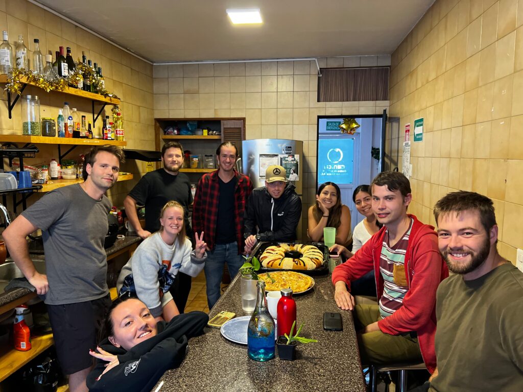 Grupo de personas en cocina con comida sobre la mesa.