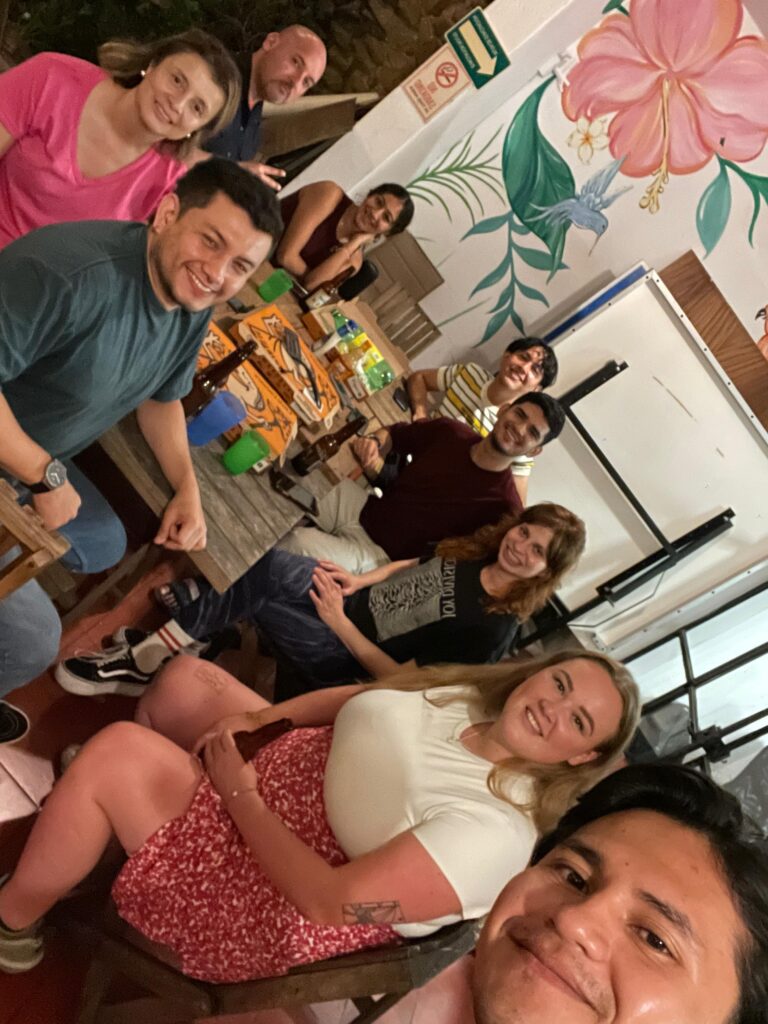 Grupo de amigos en reunión con pizza y bebidas.