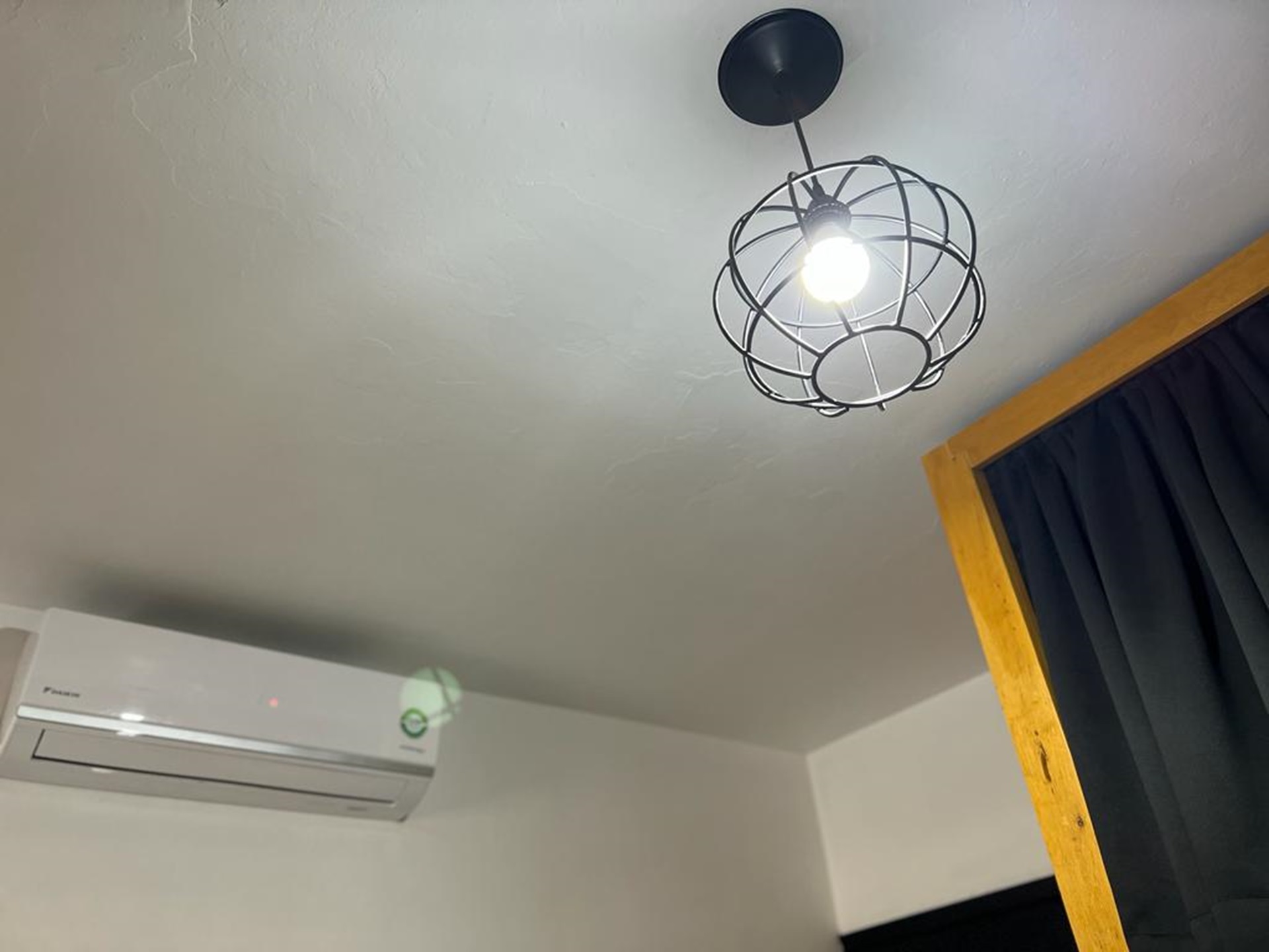 Lámpara moderna y aire acondicionado en habitación.