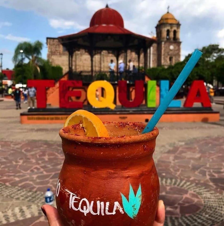 Jarra de tequila en plaza con letras coloridas.